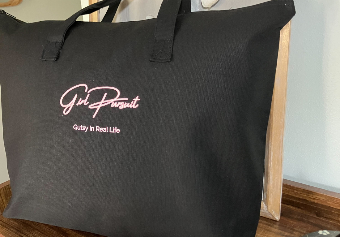 large black tote sitting on a desk leaning against artwork.