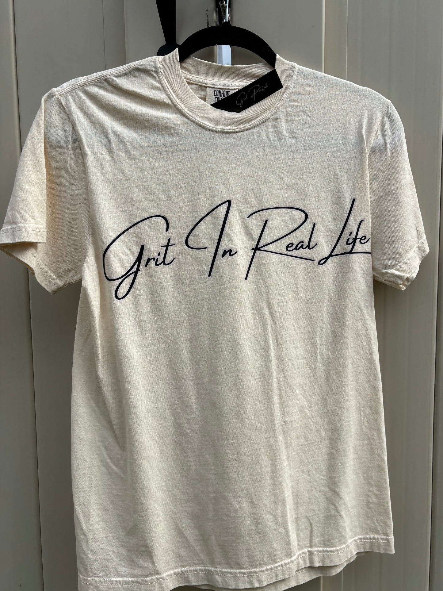 White t-shirt with black text on a gray surface