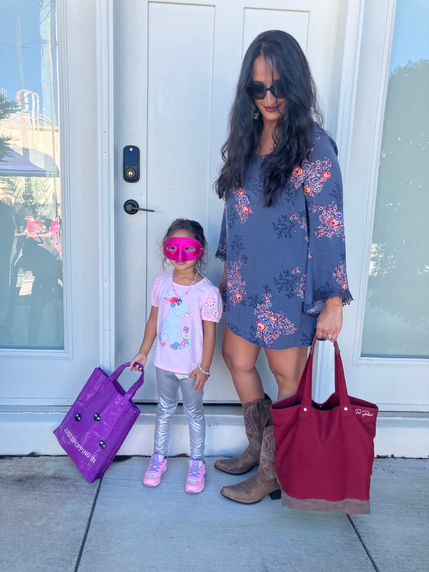 Woman and child standing outside a house with a purple bag child holding & Mom holding Girl Pursuit Bag.